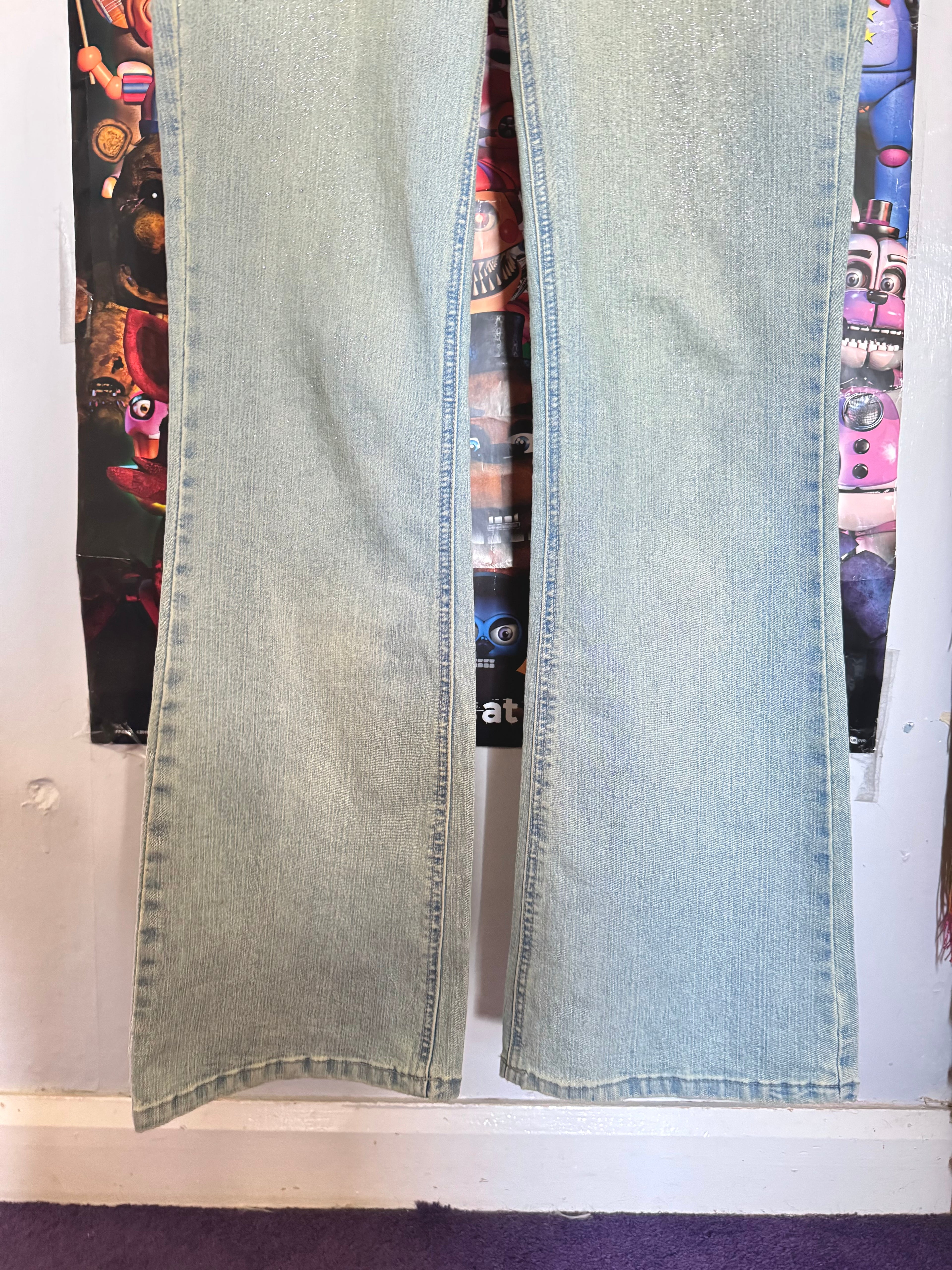 y2k vintage mid waisted light wash denim flared jeans with buckle and shimmer throughout